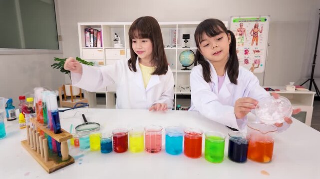 Two Schoolgirls Conducting Colorful Science Experiments in Classroom Laboratory