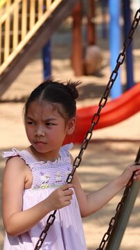 Young Thai Girl Holding Swing Chains at Lumpini Park Playground