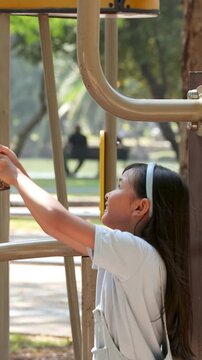 Young Thai Girl Playing on Exercise Equipment in Lumpini Park