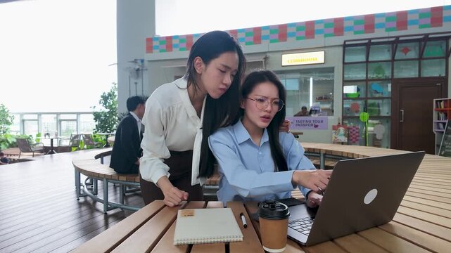 Stressed Asian Businesswomen Working on Laptop in Modern Bangkok Office