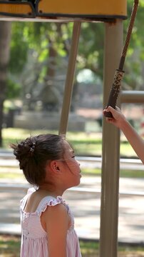 Young Asian Girl Playing on Outdoor Exercise Equipment in Bangkok