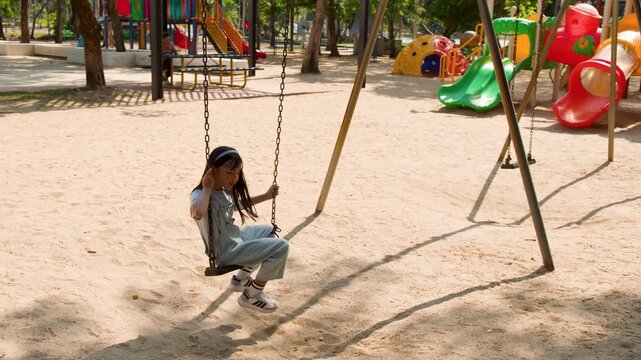 Young Thai Girl in Blue Jumpsuit Playing on Swing at Lumpini Park
