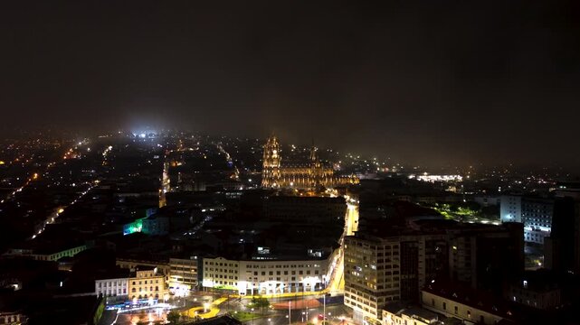 Night Aerial View of Quito Ecuador Historic Center with Illuminated Basilica, City Streets, Foggy Sky and South American Capital Skyline