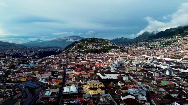 Wide Aerial View of Quito Ecuador Cityscape with El Panecillo Hill, Dense Urban Buildings, Clouds and High Altitude Capital Landscape
