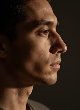 Close Portrait Of Individual With Profile Facing Towards Left Side Frame Against Dark Background Serves As Stark Contrast Highlighting