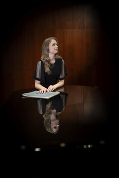 Young woman, pianist, with notes by Johann Sebastian Bach in concert hall, supported on Steinway & Sons grand piano, Stuttgart, Baden-W&uuml;rttemberg, Germany