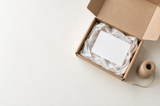 Open parcel with blank card tissue paper and twine