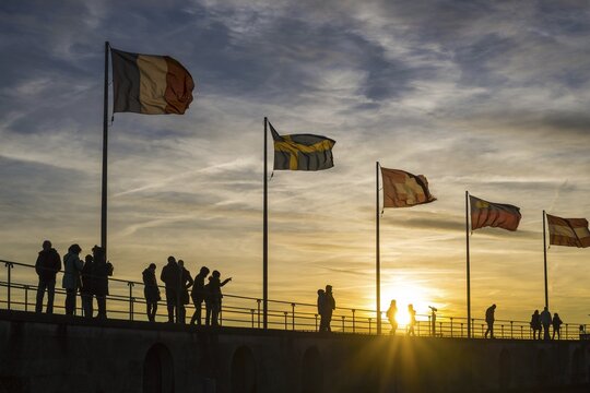 People, silhouettes, flags, harbour in Lindau am Lake Constance, Bavaria, Germany