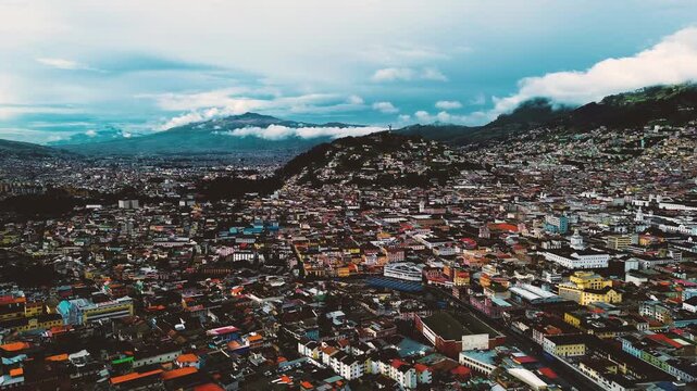Drone View of Quito Ecuador Mountain Basin with Dense Urban Buildings, Low Clouds, Green Hills and Scenic High Altitude South American Cityscape
