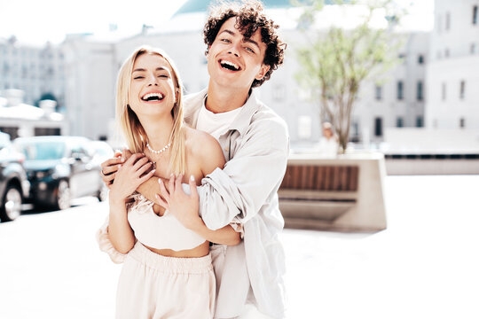 Portrait of young smiling beautiful woman and her handsome boyfriend in casual summer clothes. Happy cheerful family. Female having fun. Couple posing in the street background at sunny day