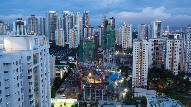 Day to night timelapse of modern city skyline with active construction cranes and glowing sunset