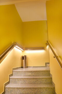 Yellow Staircase with Illuminated Handrails and polished terrazzo floor.
