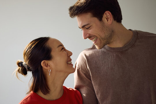Happy multiracial couple in love looking at each other.