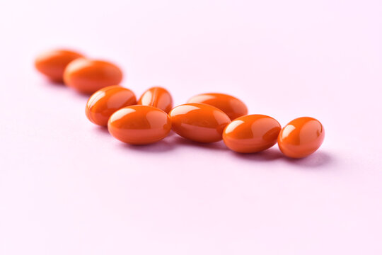 Lutein capsules. Dietary supplement on bright paper background. Soft focus. Close up. Copy space.