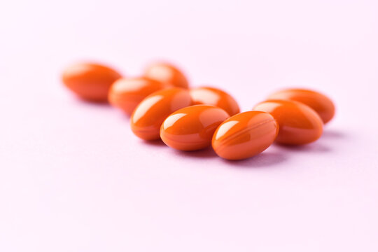 Lutein capsules. Dietary supplement on bright paper background. Soft focus. Close up. Copy space.