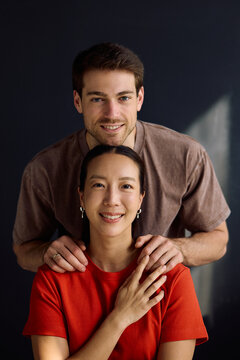 Portrait of happy multiracial couple looking at camera.