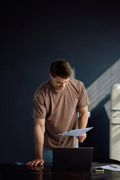 Happy man analyzing his financial reports while working at home.