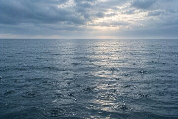 Obraz premium Raindrops Creating Ripples on Calm Ocean Surface