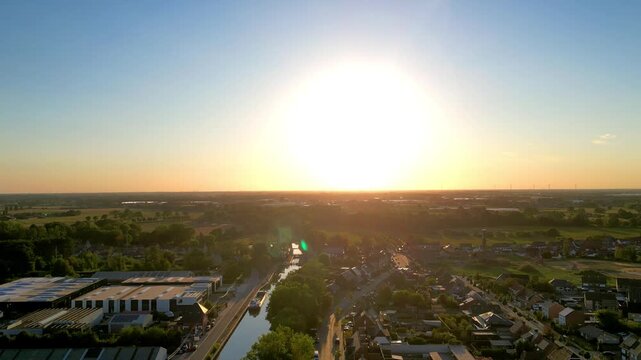 Golden Hour Aerial Flight Over a Picturesque European Town and Canal Towards a Brilliant Sunset