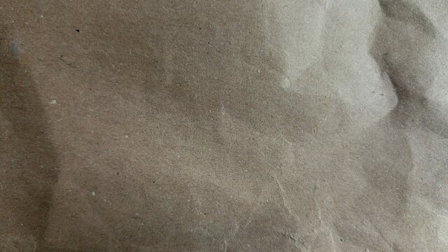 Crinkled brown paper texture fills the frame with subtle folds