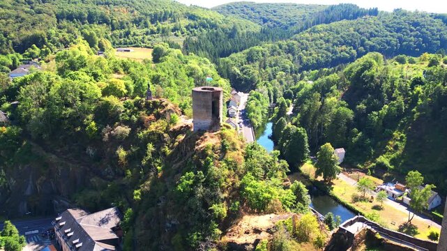 September 10, 2026 - Aerial drone footage of the historic Esch-sur-S&ucirc;re castle ruins and tower overlooking the scenic river valley in Luxembourg.