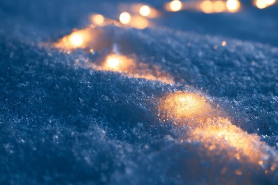 Snow covered ground with glowing lights during winter evening