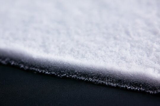 Close up view of a white textured material on a black background showcasing details and patterns