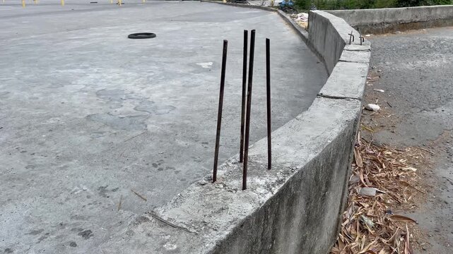 Close up view of vertical steel rebar sticking out from concrete foundation