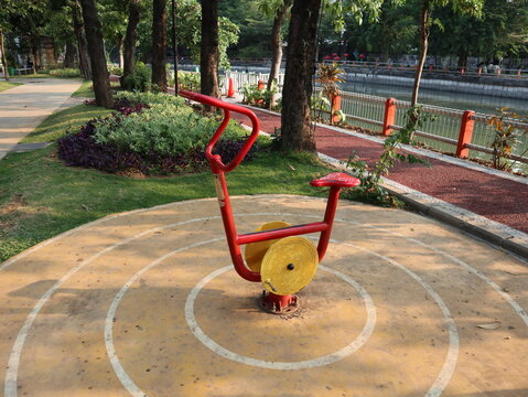 Outdoor stationary exercise bike machine in a public park playground area for public physical activity.