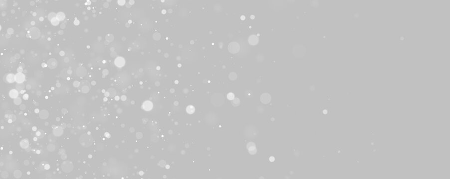 Floating particles create a bokeh effect against a dark background. Circular shapes vary in size and softness, creating a sense of depth and light diffusion.