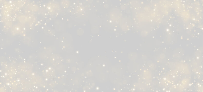 A scattering of glowing golden particles floats against a deep black background. The light points vary in size and intensity, creating a shimmering bokeh effect.
