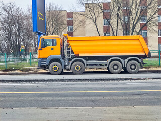 Delivery of construction materials.Orange dump truck carrying bulk cargo © Igor