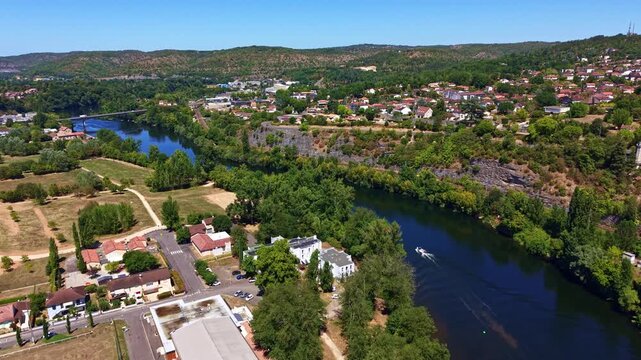 Lot River near Pont de Regourd in Cahors, Lot, Occitanie, France, follows a broad bend between wooded banks and sediment bars beneath the Quercy hills, drone forward flyover