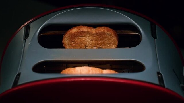 Toaster Toasting Bread
Close up of a toaster browning fresh bread for breakfast and hand takes them out in slow motion