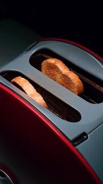 Toaster Toasting Bread
Close up of a toaster browning fresh bread for breakfast and hand takes them out in slow motion