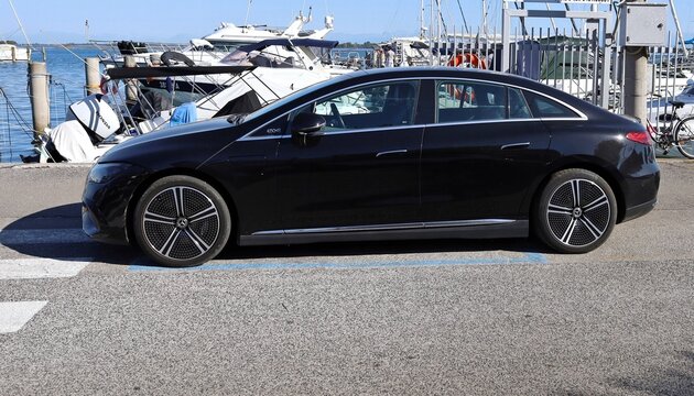 Grado, Italy. September 8, 2026. Black Mercedes-Benz EQE Berlina outside a marina pier. It is a full electric luxury&nbsp; car of the german automaker.
