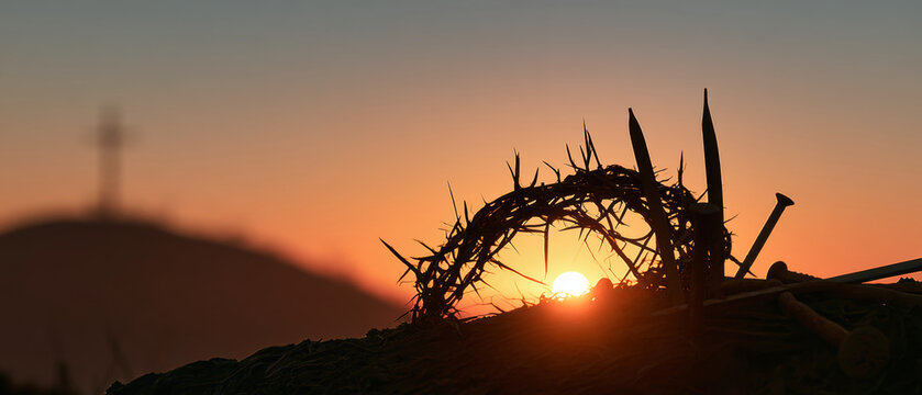 A crown of thorns sits in the foreground as the sun sets behind a mountain. Nails are nearby, and a cross is faintly visible in the distance