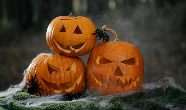 Spooky and scary Halloween themed image in a dark forest with Jack-o-lanterns.
