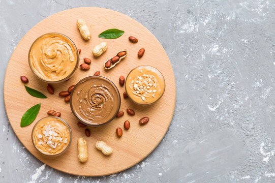 Glass jar with peanut butterin plate on table background, top view space for text and close up