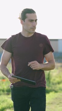 Young agronomist using a tablet to monitor plant growth in an urban garden. Smart farming technology for sustainable agriculture and horticulture. Vertical