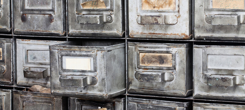 Antique card catalog and document storage system, vintage metal worn drawers. Archive concept, office furniture poster, retro banner