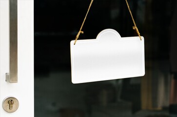 Blank hanging sign on glass door with copy space