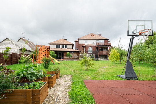 Basketball hoop and wooden garden beds in suburban backyard