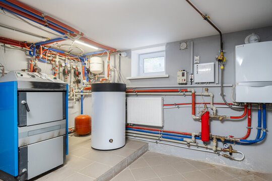 Industrial boiler room heating system with white storage tank