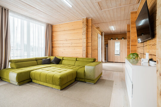 Green velvet modular sofa in log cabin living room