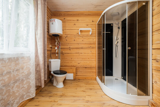 Shower enclosure and toilet inside log cabin bathroom
