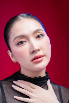 A bold woman points directly at the camera with a confident smirk, dramatic foreground blur and sharp gaze against a vivid red backdrop, radiating attitude and defiance.