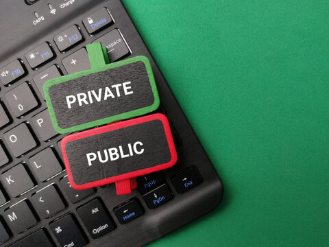 Green and red tagged clips reading PRIVATE and PUBLIC placed over a black laptop keyboard