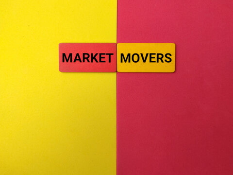 Two wooden blocks reading MARKET MOVERS sit at the center of a yellow and red split background