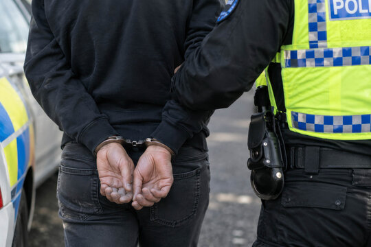 Arrested Person Being Detained by Police Officers During Criminal Investigation